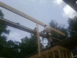 Carpenter setting a ridge beam over a new addition frame — Ice Dam Removal by Roofing Brothers in Redfield