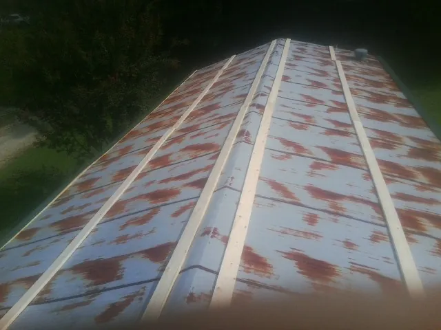 Rusted metal roof panels with new wood purlins before replacement — Storm Damage Roof Repair in Redfield by Roofing Brothers