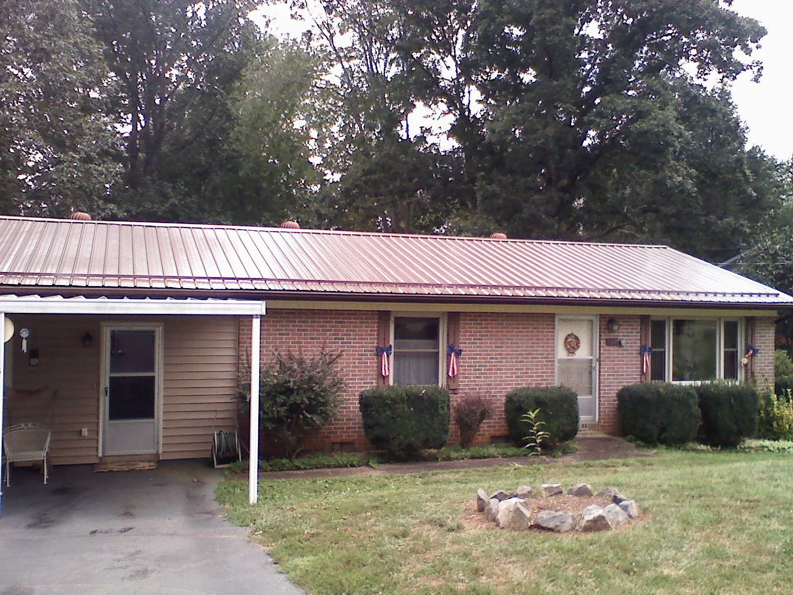 Bronze metal roof and carport on a brick ranch home — Roof Repair work by our crew in Redfield